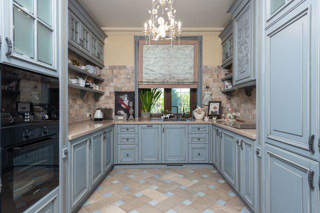 a blue-gray kitchen with a chandelier